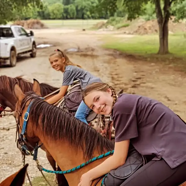 Blair and Brooke with two horses, one hugging a horse’s neck and one on horseback behind