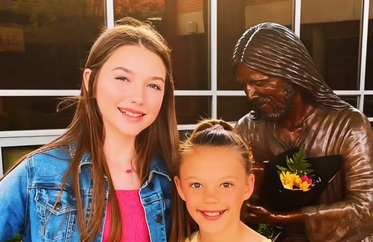 Blair and Brooke in front of a bronze statue of Jesus